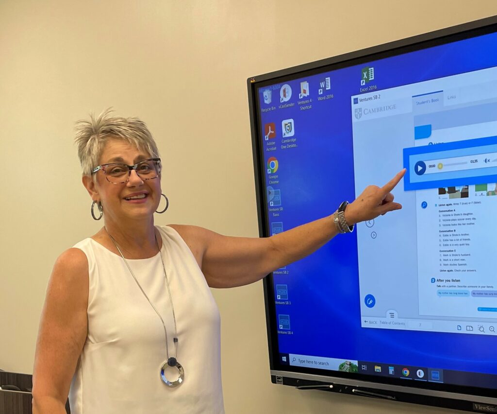 ml kursish, NFCC ESL instructor points at the smart board during a lesson